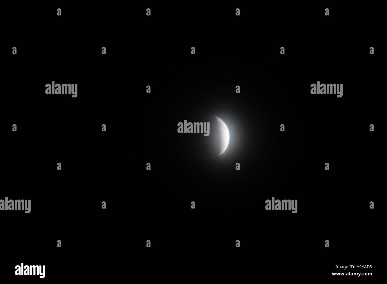 Questa fotografia cattura l'eclissi lunare totale del 14 aprile 2014, mostrando la tonalità rossastra della luna mentre entra nell'ombra della Terra durante l'evento astronomico. L'immagine evidenzia la bellezza e la rarità di questo fenomeno celeste. Foto Stock