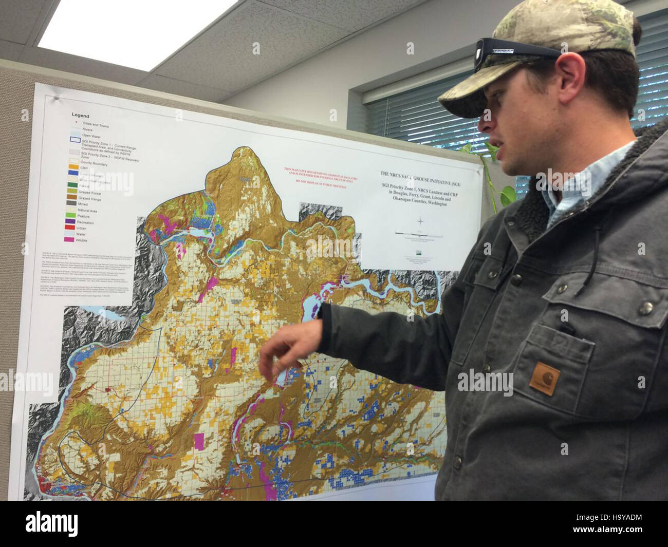 Questa fotografia mostra Michael Brown, probabilmente un funzionario del governo, che punta su una mappa. L'immagine cattura il momento preciso della discussione o del briefing, sottolineando l'importanza della pianificazione e del coordinamento. Foto Stock