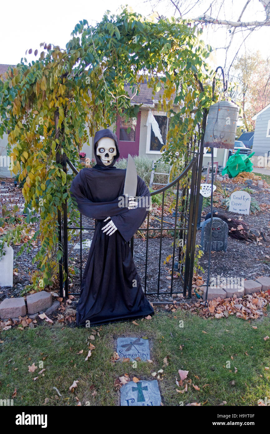 Halloween Grim Reaper con scheletro mannaia grande cimitero di guardia gate nel cortile anteriore della casa. Fergus Falls Minnesota MN USA Foto Stock