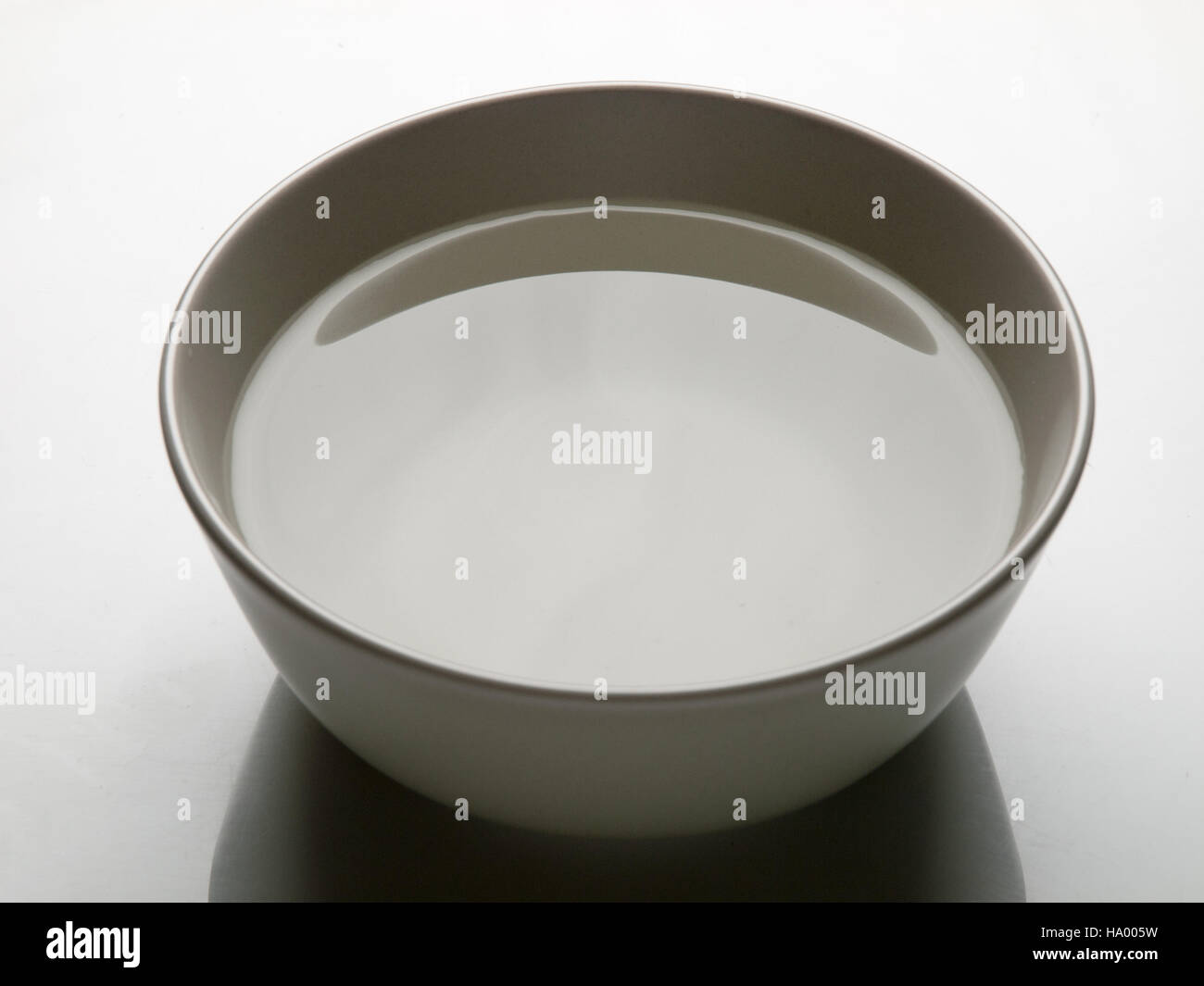 Ciotola con acqua in uno sfondo bianco Foto Stock