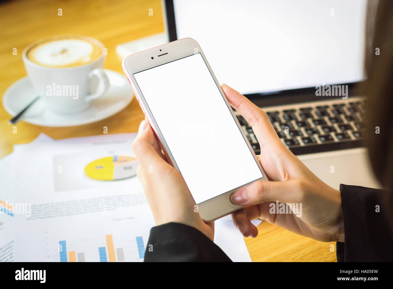 Mano utilizzando phone schermo bianco su tavola Foto Stock