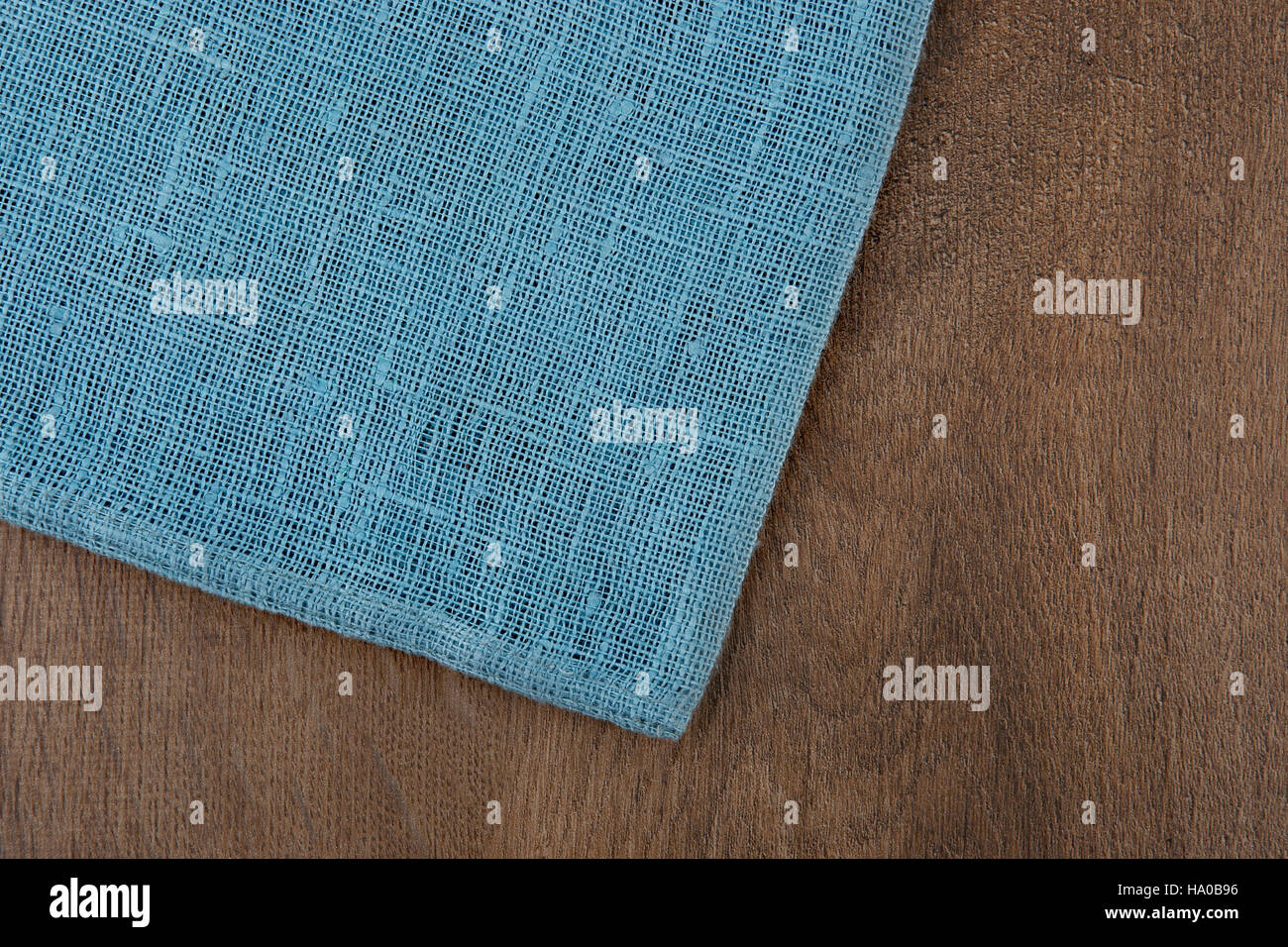 Tovagliolo da sinistra tavolo in legno. Morbido tessuto blu tessuto di lino texture / legno texture. Grossi sacchi di iuta. Vista superiore dello sfondo. Foto Stock