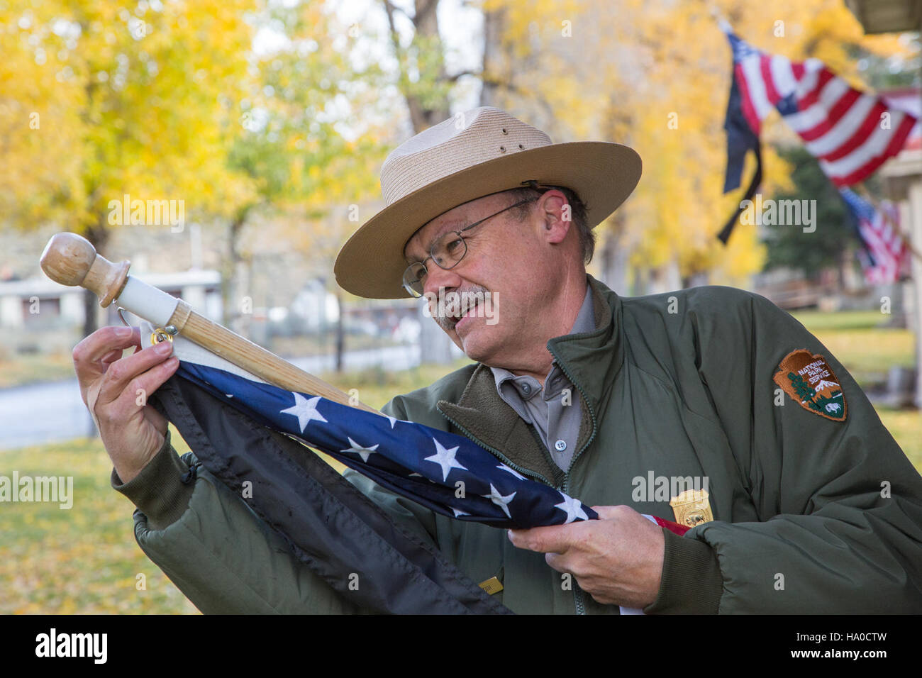 I ranger del parco nazionale di Yellowstone onorano la giornata nazionale dei vigili del fuoco attaccando nastri neri alle bandiere lungo la fila degli ufficiali, riconoscendo i sacrifici e il coraggio dei vigili del fuoco a livello nazionale. Foto Stock