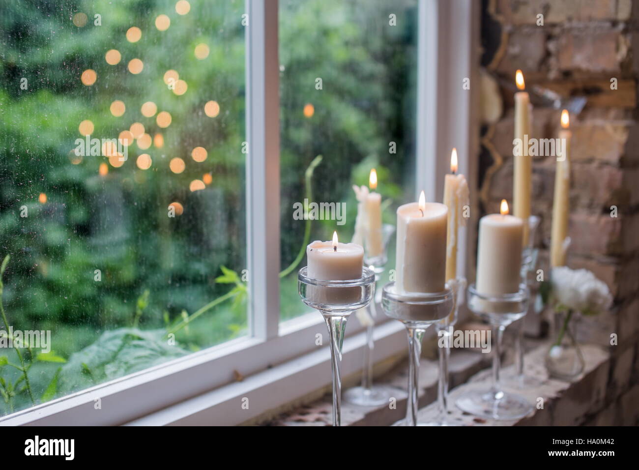 Candele bianche in vetro i titolari. Bellissimo rustico decorazione di  nozze. La luce di una candela che riflette nella finestra . Stile Loft  matrimonio. Sfondo sfocato Foto stock - Alamy