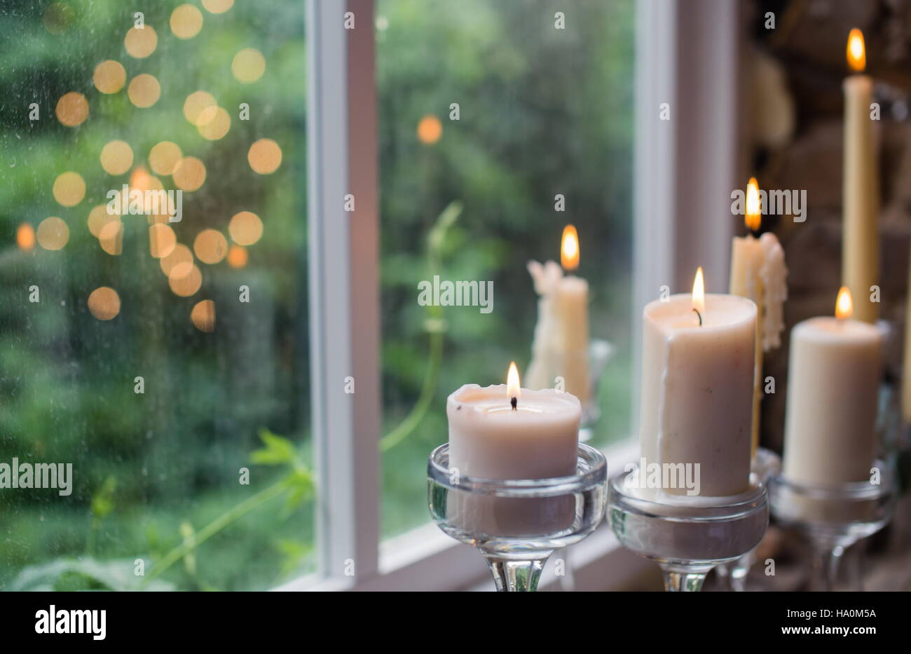 Candele bianche in vetro i titolari. Bellissimo rustico decorazione di  nozze. La luce di una candela riflessione nella finestra . Stile Loft  matrimonio Foto stock - Alamy