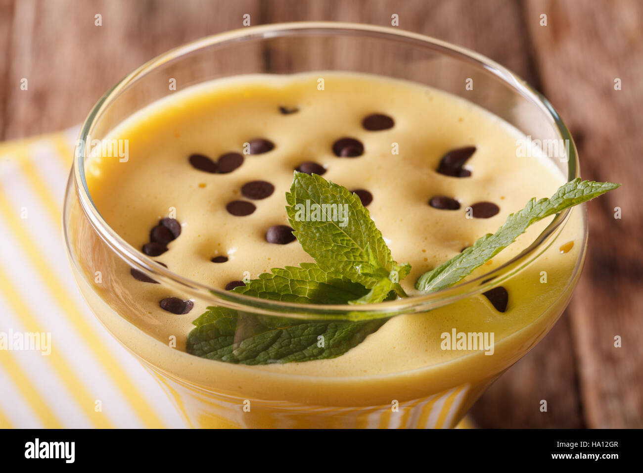 Crema di uovo Zabaione con gocce di cioccolato e menta in una macro di vetro orizzontale. Foto Stock