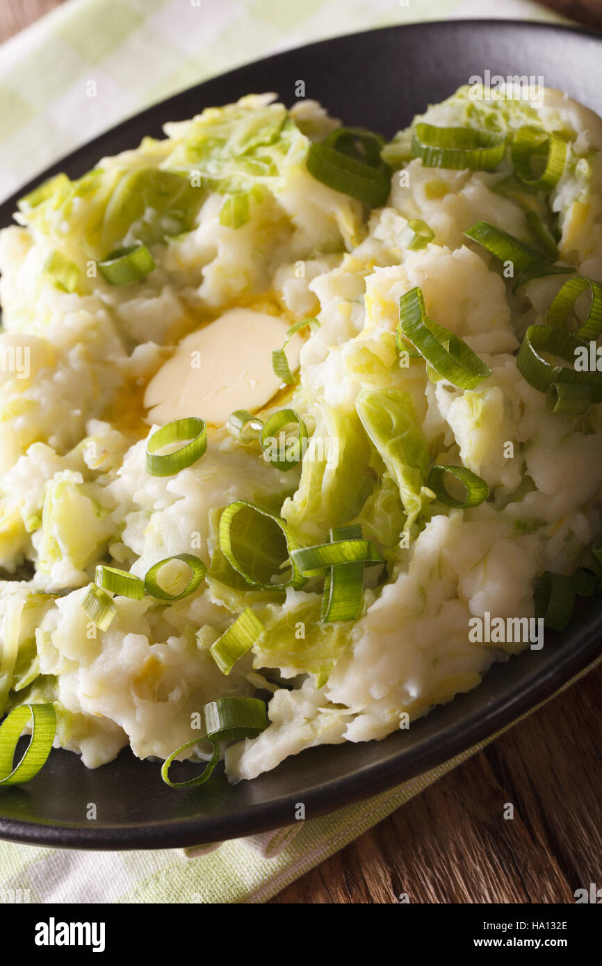 Cucina irlandese: colcannon purè di patate con cavolo verza e burro su una piastra macro verticale. Foto Stock