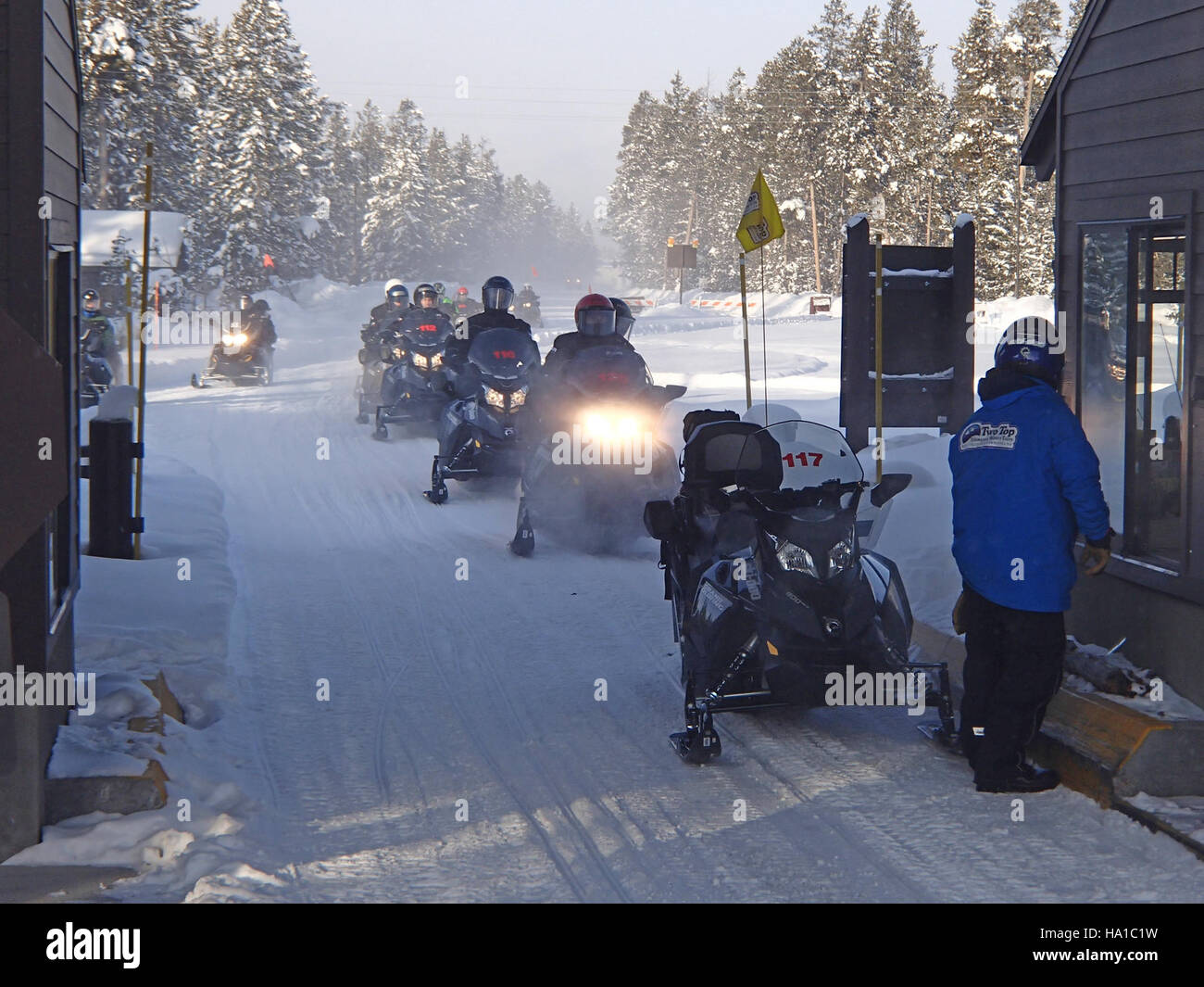 Le motoslitte sono in fila in attesa di entrare nel parco nazionale di Yellowstone durante la stagione invernale. Il parco è una destinazione popolare per le attività ricreative invernali, tra cui escursioni in motoslitta, e offre opportunità uniche per esplorare i suoi paesaggi ghiacciati. Foto Stock