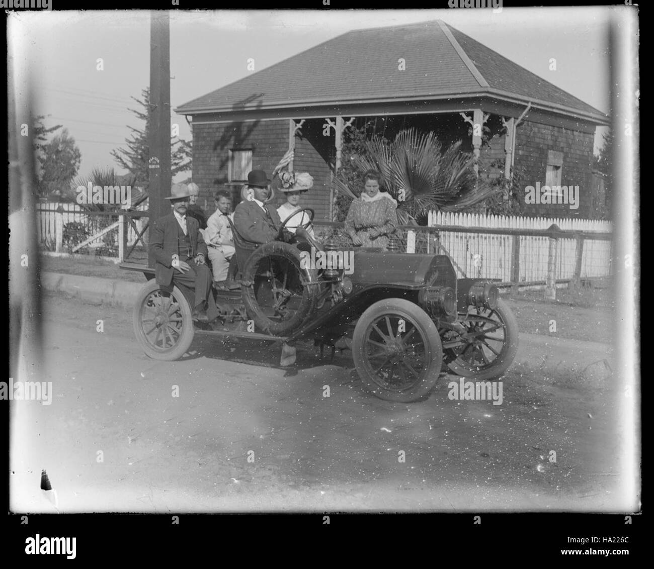 Una fotografia storica del San Francisco Maritime National Historical Park con un gruppo in una delle prime automobili, che rappresenta la vita e i trasporti dei primi anni del XX secolo. Foto Stock