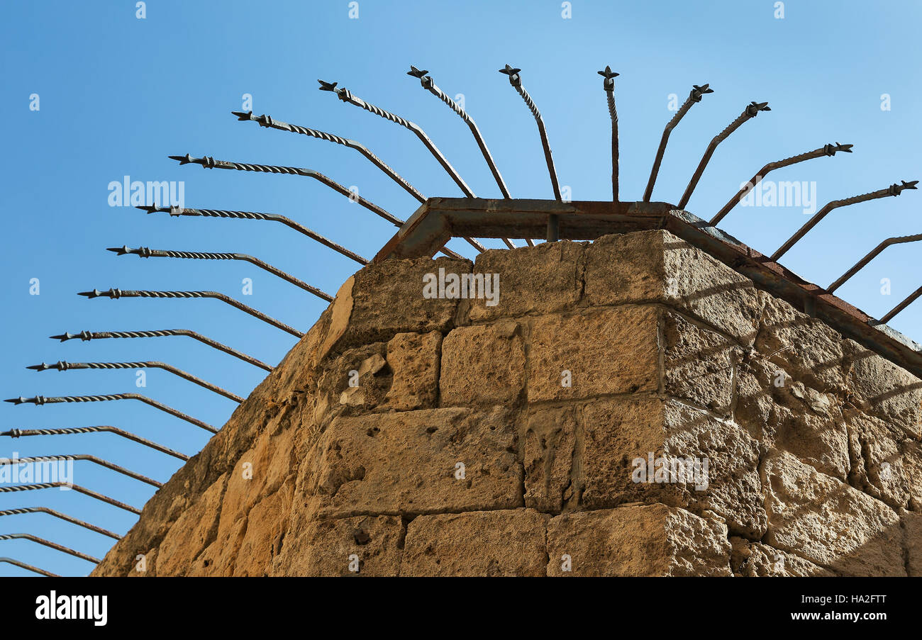 Muro di fortificazione con picchi di ferro contro il cielo in Akko Foto Stock