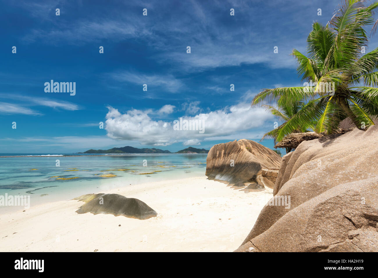 Spiaggia tropicale a Seychelles, La Digue Island e l'isola di Praslin all'orizzonte. Foto Stock