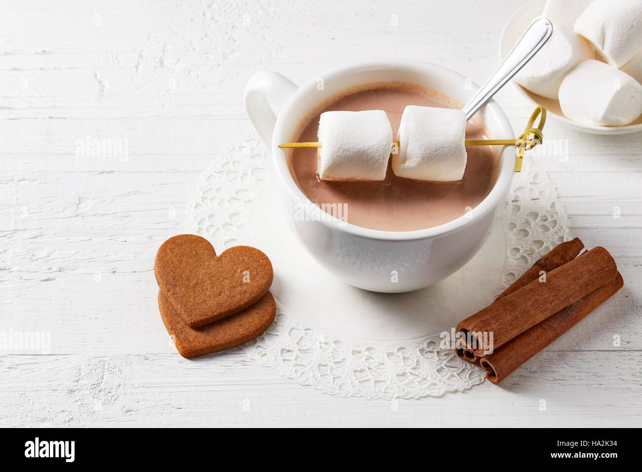 Tazza di cioccolata calda a bere con dolci bianco sul tavolo di legno Foto Stock