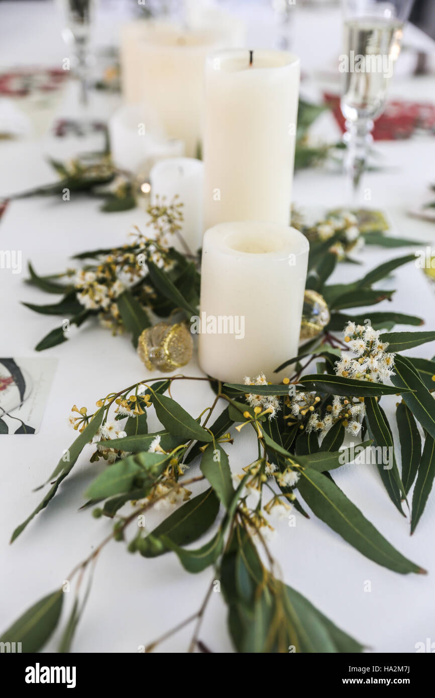 Candele e centrotavola di eucalipto sul tavolo da pranzo Foto stock - Alamy