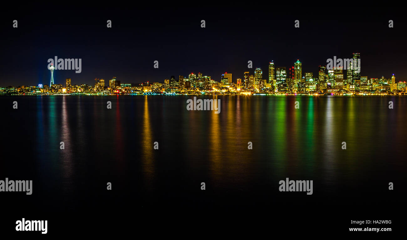 Il Seattle skyline notturno come visto da di Alki. Una lunga esposizione consente di Puget Sound immergetevi i colori della città di notte. Foto Stock