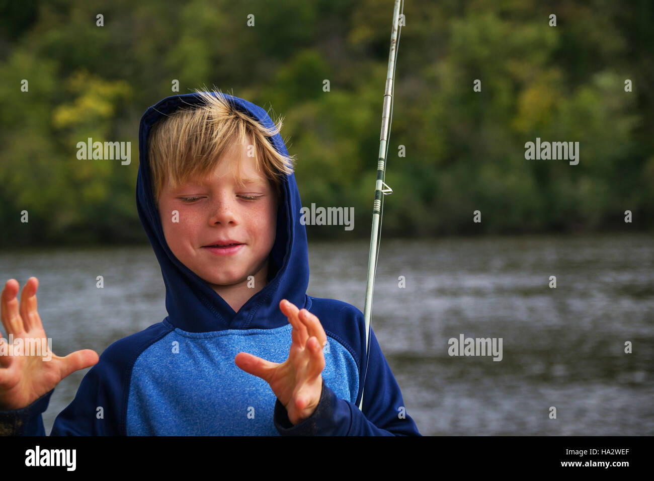 Ragazzo di pesca che mostra le dimensioni delle catture Foto Stock