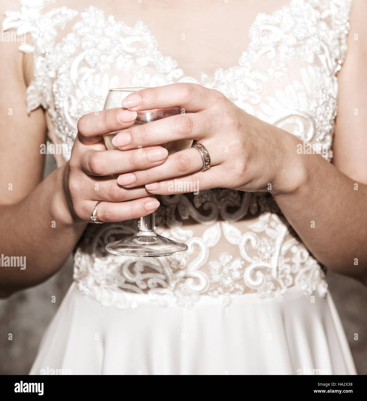 Close-up di una sposa con le mani in mano in mano un bicchiere di vino Foto Stock