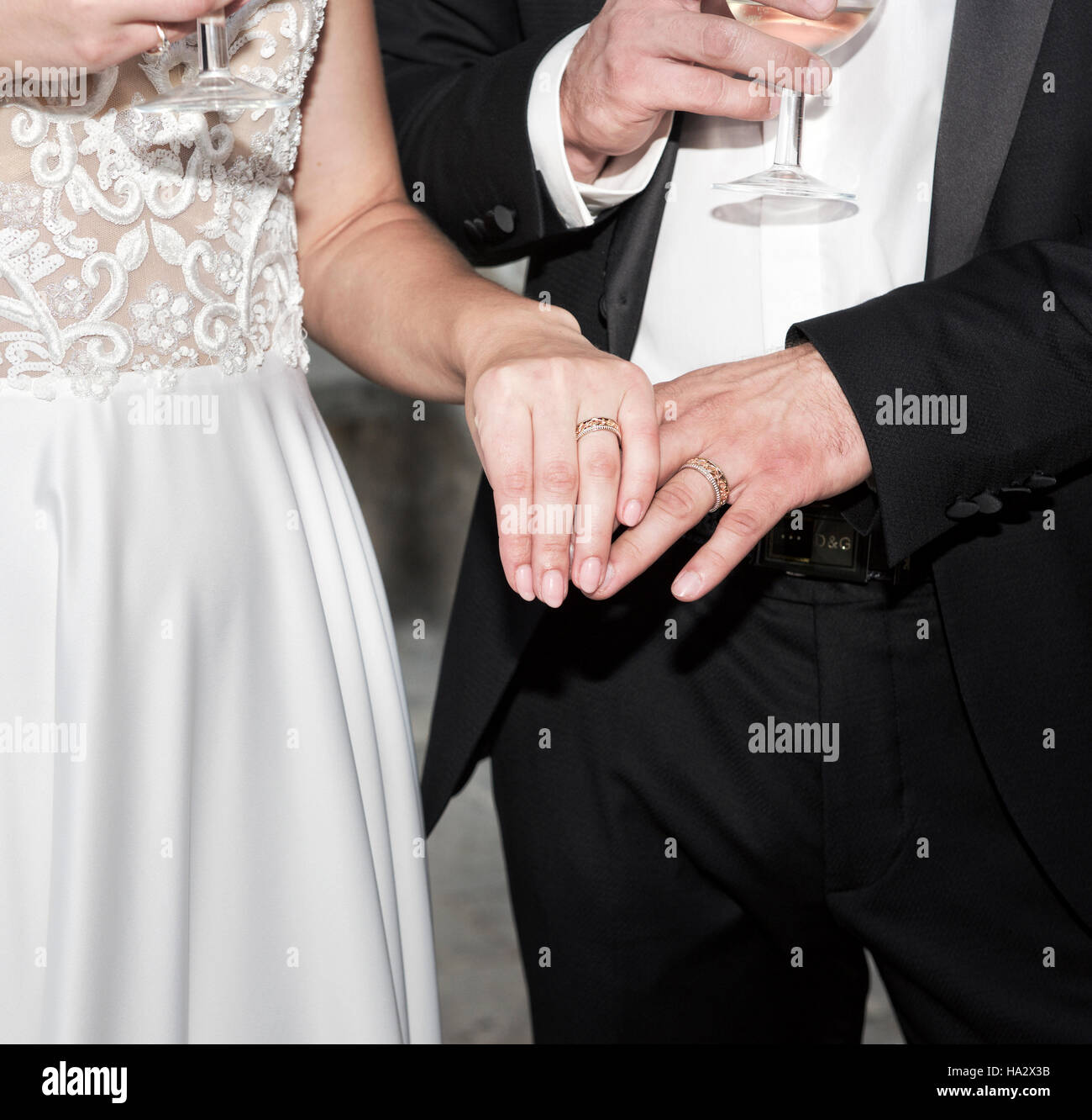 Close-up di una sposa e lo sposo tenendo le mani al loro matrimonio Foto Stock