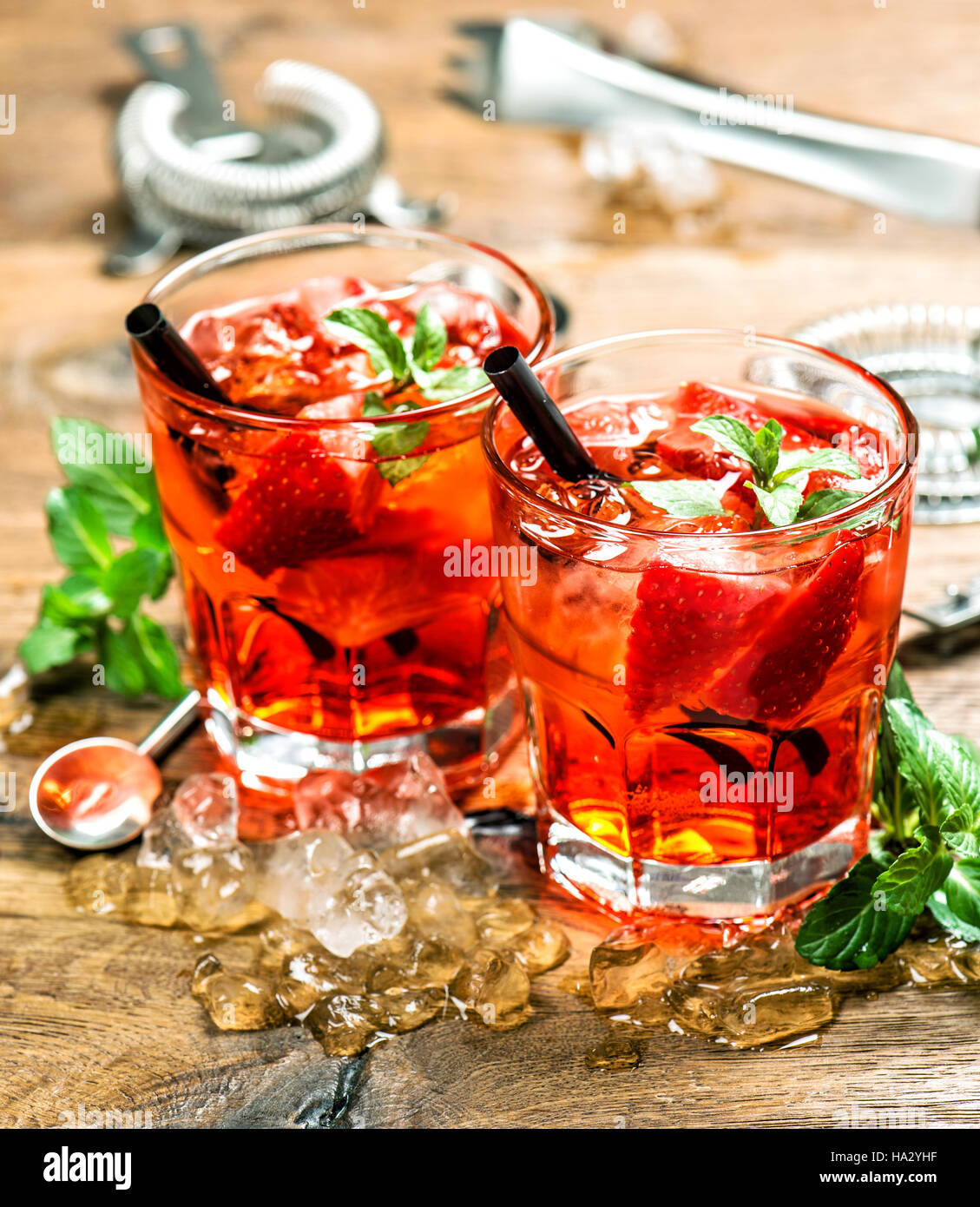 Parte delle bevande con ghiaccio e succo di frutta. Cocktail bar rendendo gli strumenti, fragola, foglie di menta Foto Stock