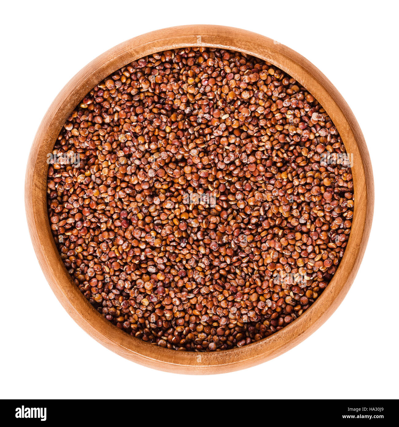 Quinoa rosso semi nella ciotola di legno. Frutti commestibili del raccolto di grano Chenopodium quinoa nella famiglia di amaranto è un pseudocereal. Foto Stock