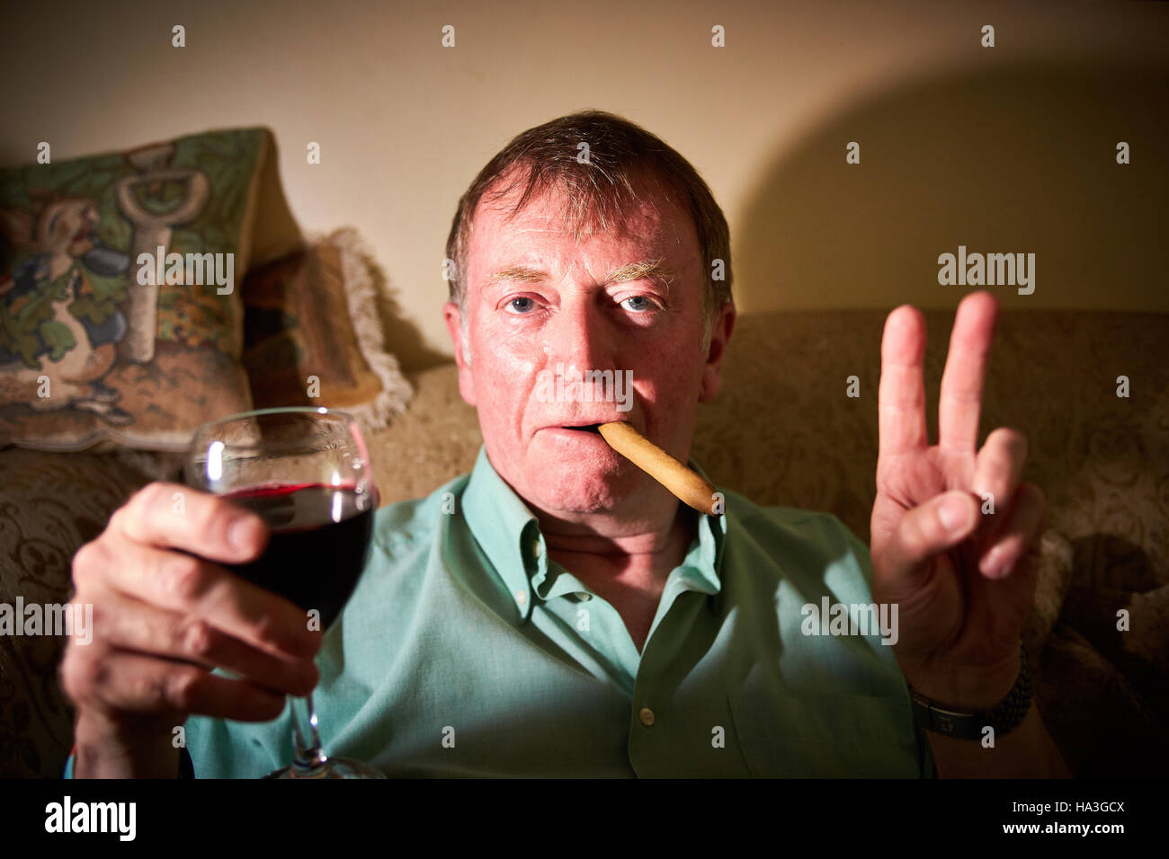 Bruce Shelton, che ha scritto un libro intitolato la lotta contro il cancro con un bicchiere di vino rosso e sigari nella foto a casa sua Foto Stock
