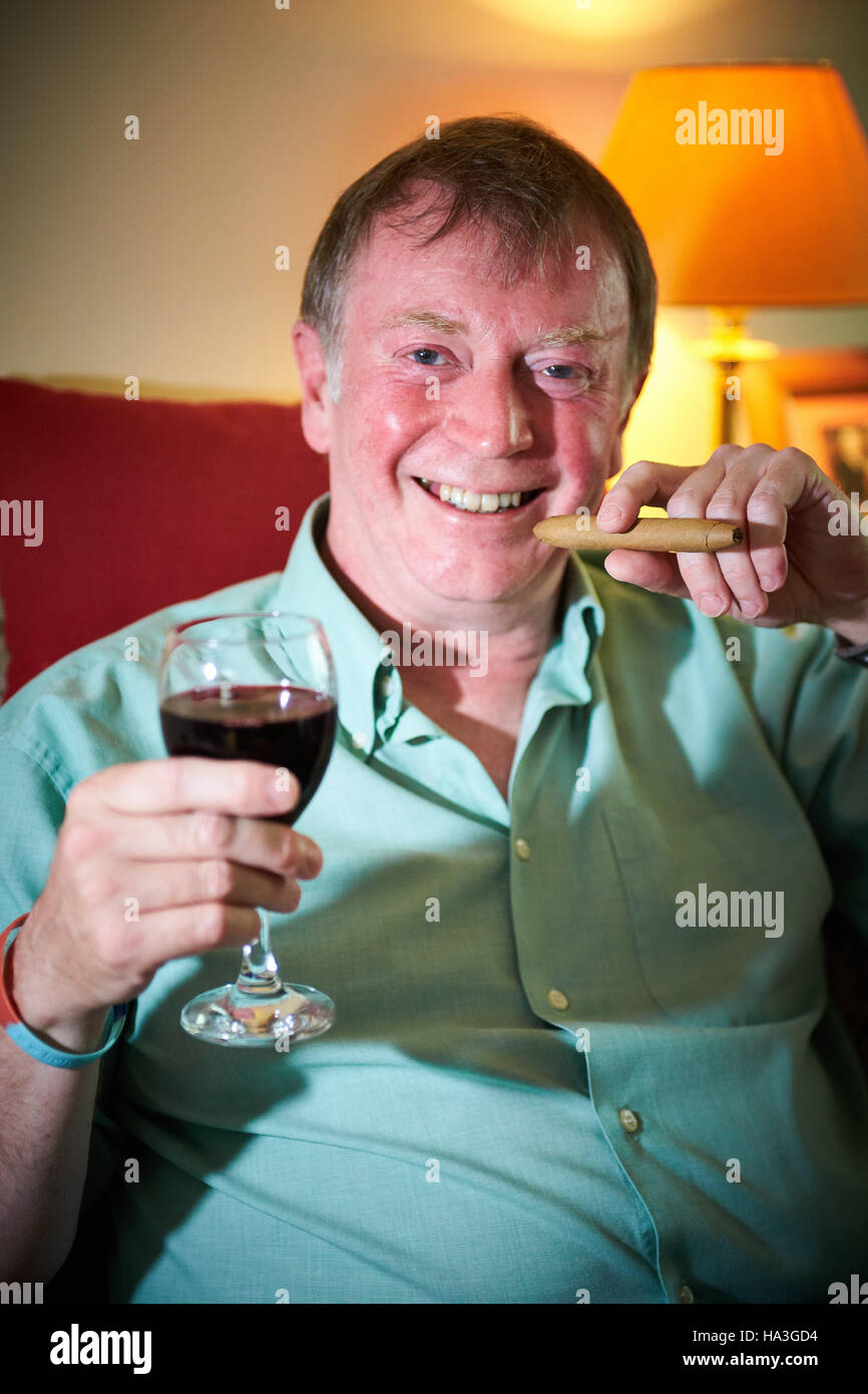 Bruce Shelton, che ha scritto un libro intitolato la lotta contro il cancro con un bicchiere di vino rosso e sigari nella foto a casa sua Foto Stock