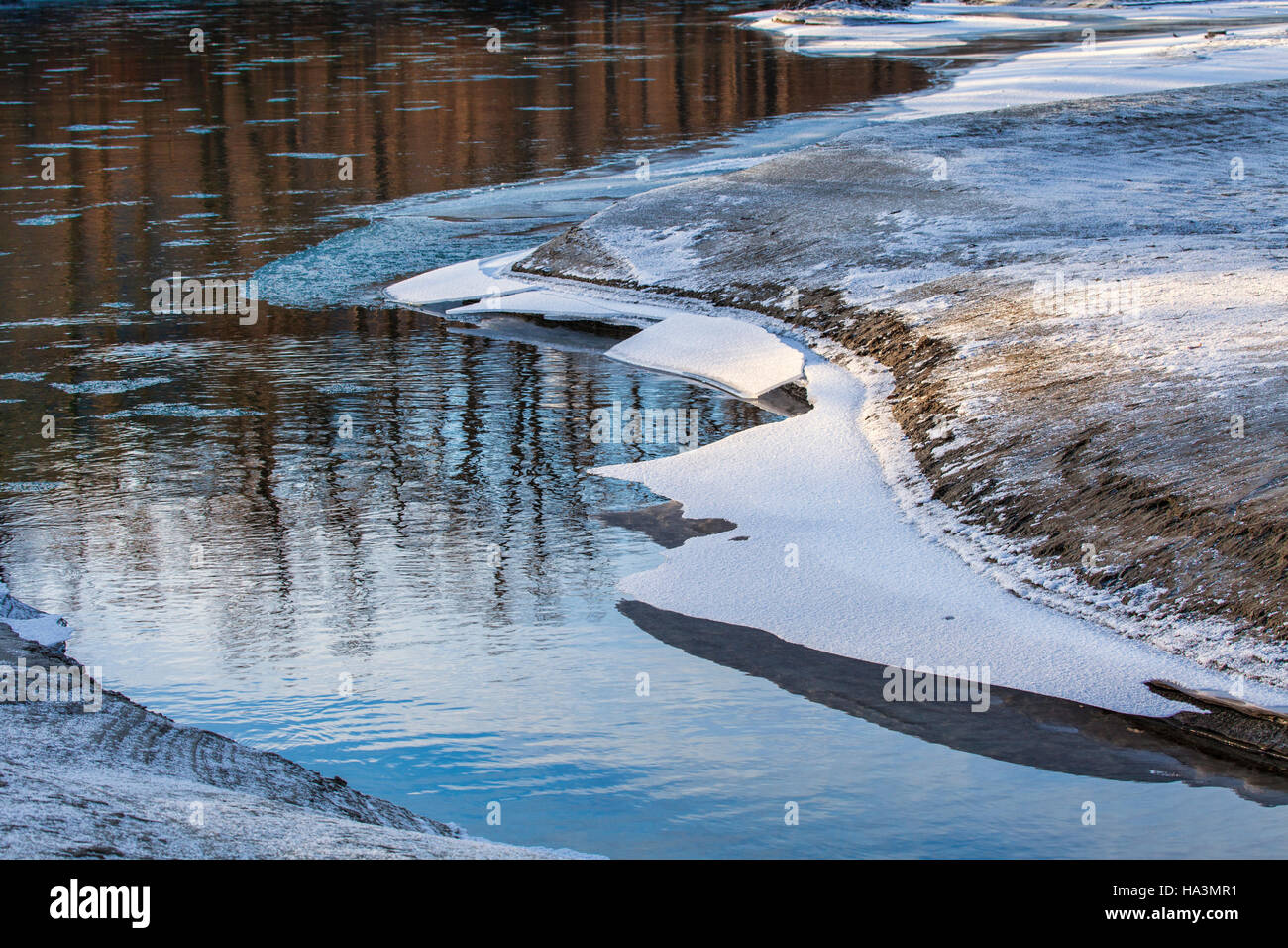 La formazione di ghiaccio sul fiume Chilkat vicino Haines Alaska nel tardo autunno con tree riflessi di luce calda vicino al tramonto. Foto Stock