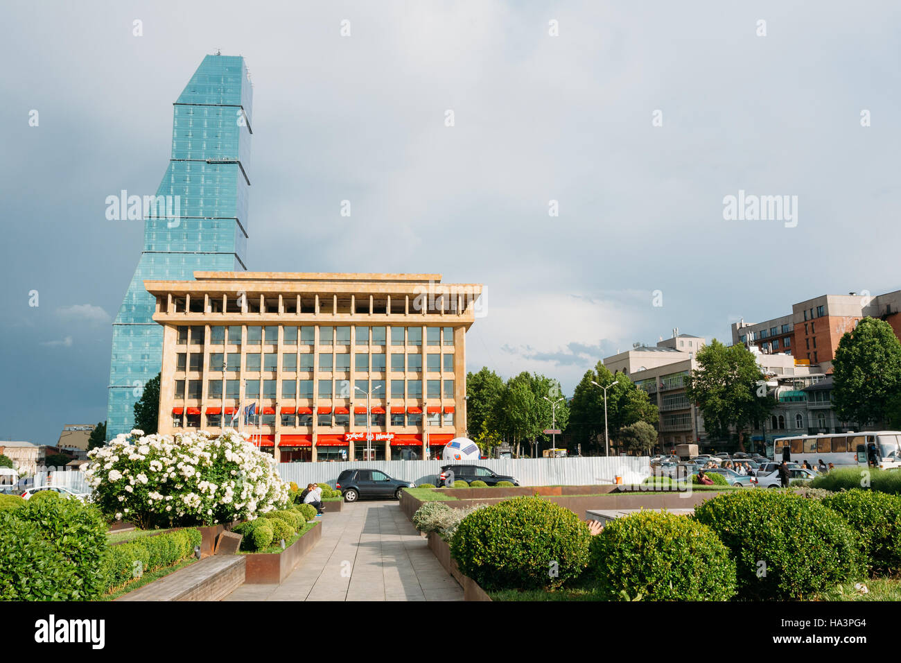 Tbilisi, Georgia. Vista del centro business e costruire Biltmore Hotel. Pubblico di piccole città giardino in primo piano Foto Stock