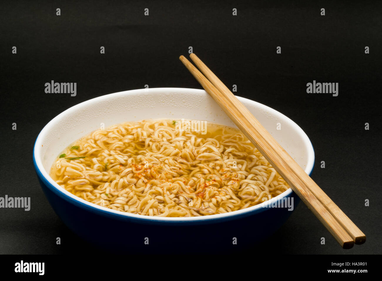 Istante di cotto riso tagliatelle in una ciotola su sfondo scuro Foto Stock