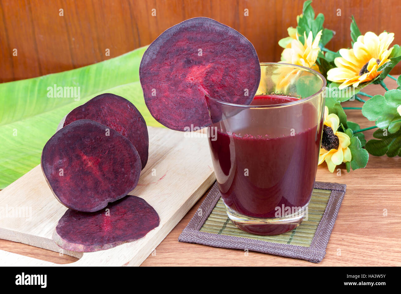 Freschi fette di barbabietole rosse e barbabietola succo di frutta in vetro un Sfondo legno Foto Stock