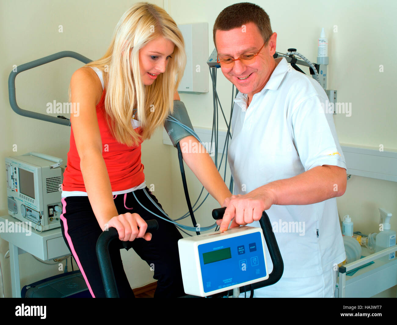 Medico conducendo un ergometro test in una pratica medica con una giovane donna Foto Stock