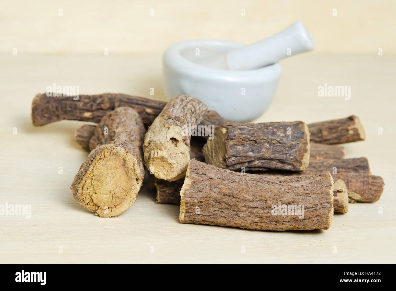 Cumulo di terra bastoncini di liquirizia isolati su legno (chiamato anche come Glycyrrhiza acanthocarpa, Glycyrrhiza glabra, glabra liquirizia, liquirizia, o di tabacco Foto Stock