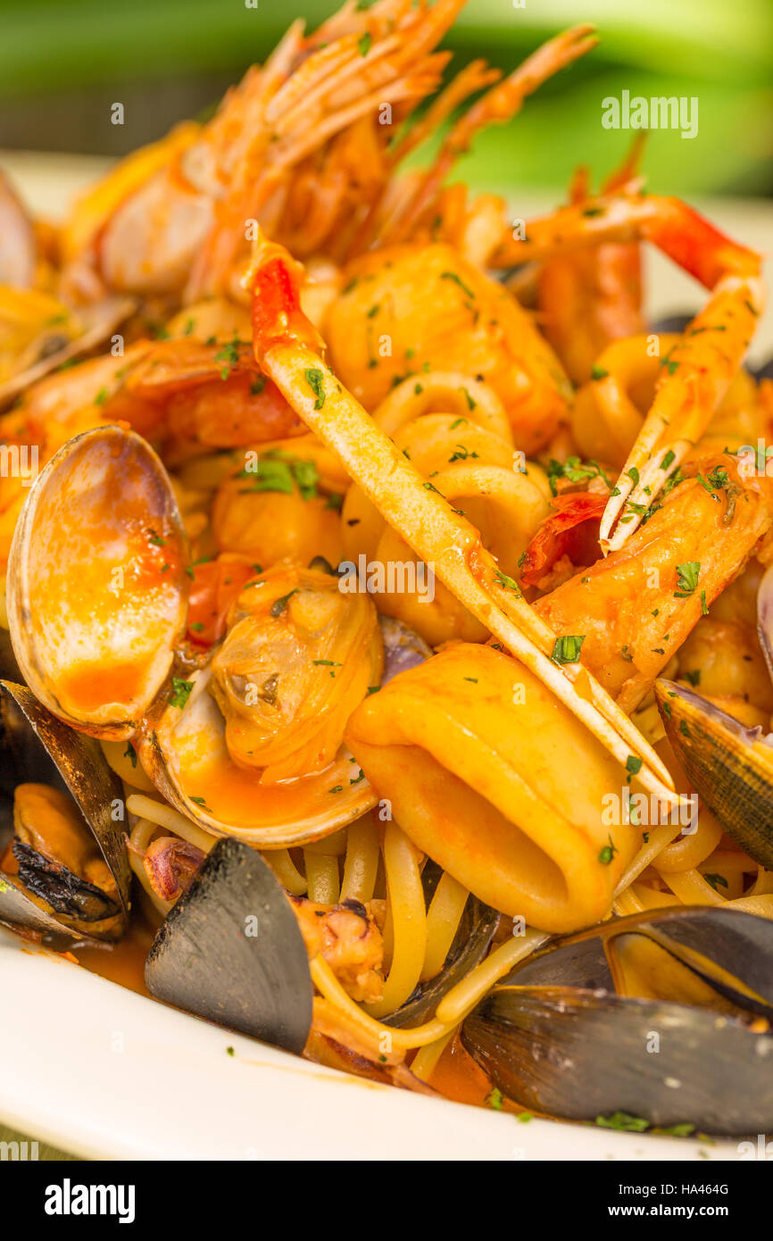 Linguine pasta condita con vongole, calamari e scampetti Foto Stock