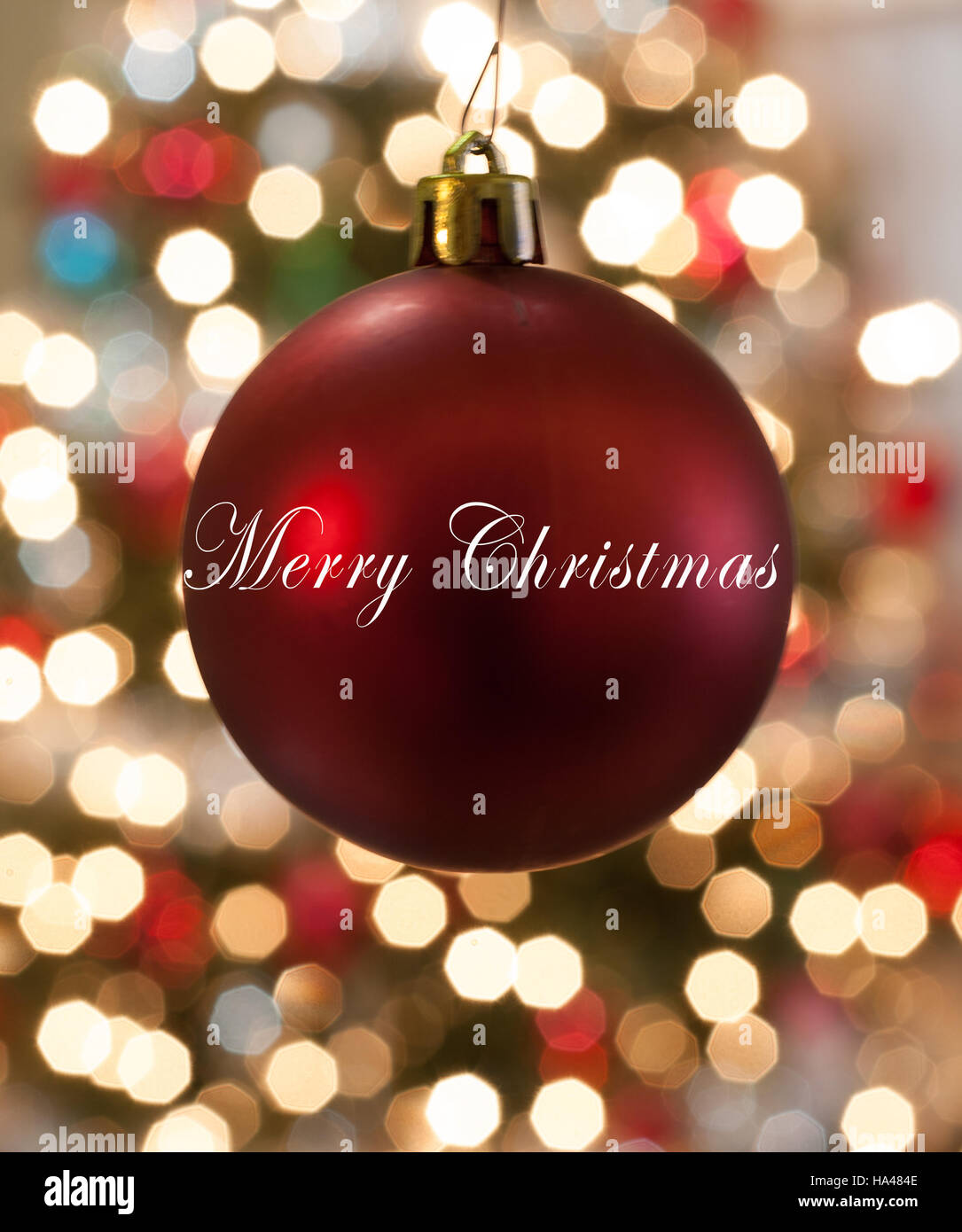 Rosso singolo Happy Holidays ornamento appeso davanti delle luci Foto Stock