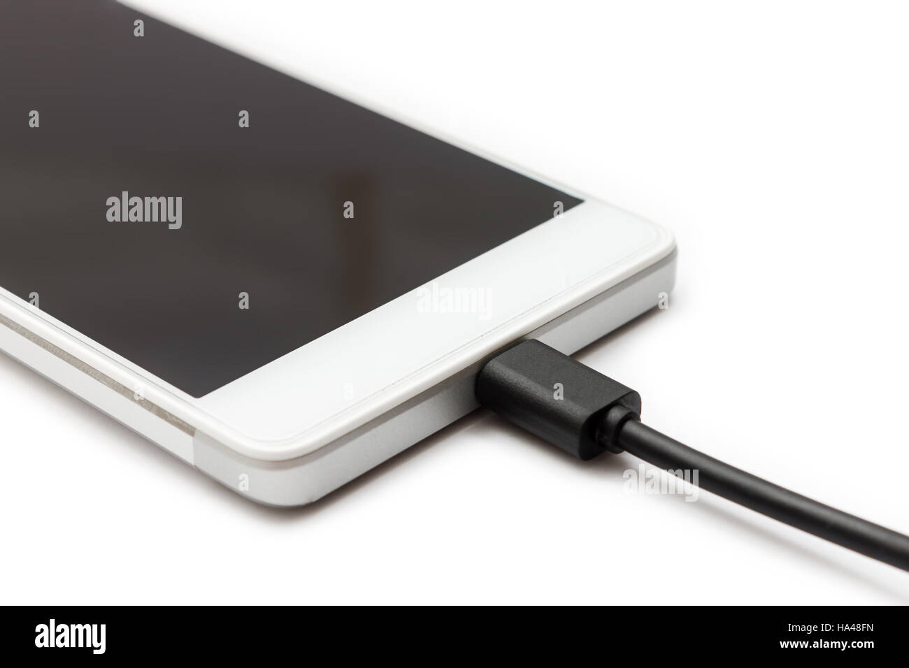 Micro USB cavo dati collegato allo smartphone. Sfondo bianco isolato. Foto Stock