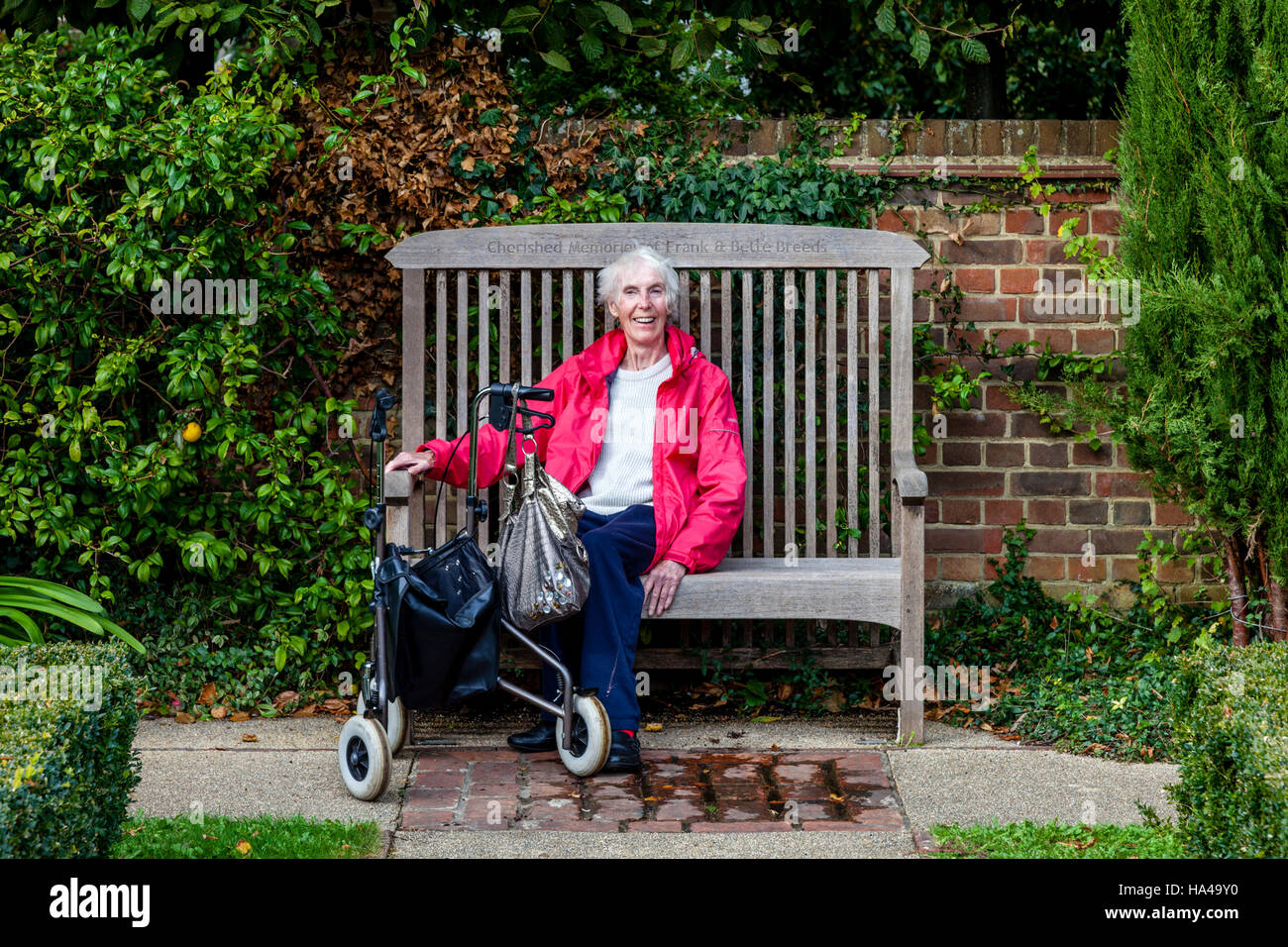 Un'anziana donna disabile seduto su una panchina, Sussex, Regno Unito Foto Stock