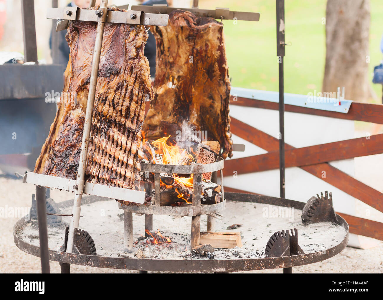 Asado, barbecue tradizionale piatto in Argentina, carne arrosto di manzo cotta su griglie verticali collocati intorno al fuoco Foto Stock