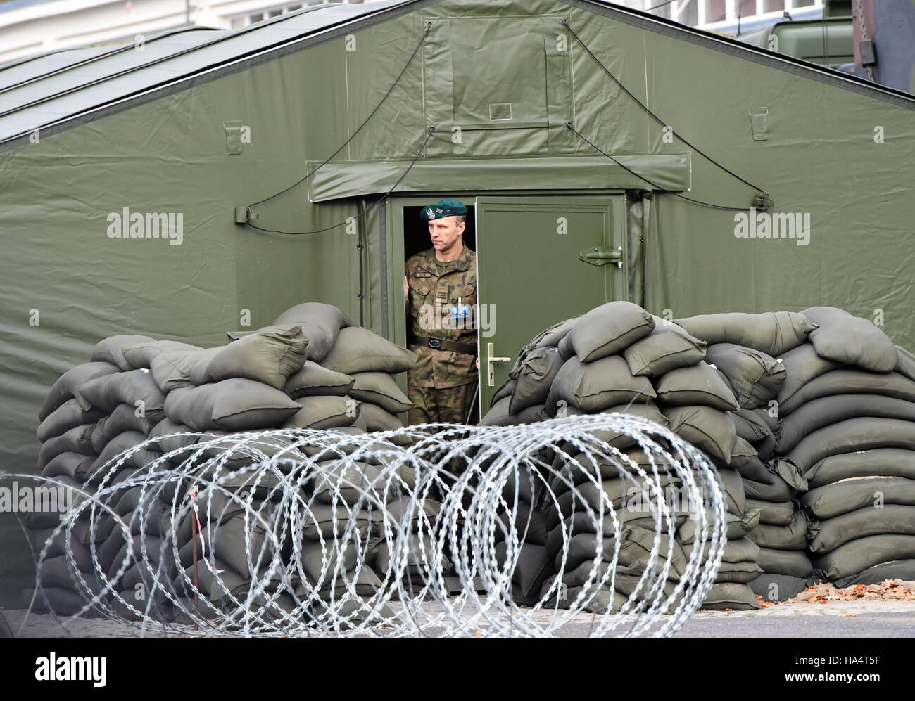 Szczecin, Polonia. 28 Nov, 2016. Un soldato del multi-nazionale NATO corps nord/est sta dietro una maglia a filo recinti durante la visita del Presidente federale tedesco Gauck in Szczecin, Polonia, 28 novembre 2016. Foto: Soeren Stache/dpa/Alamy Live News Foto Stock