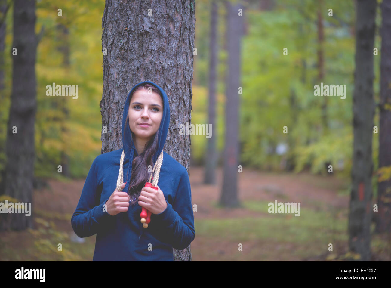 Ritratto di montare la giovane donna con salto con la corda in un parco Foto Stock