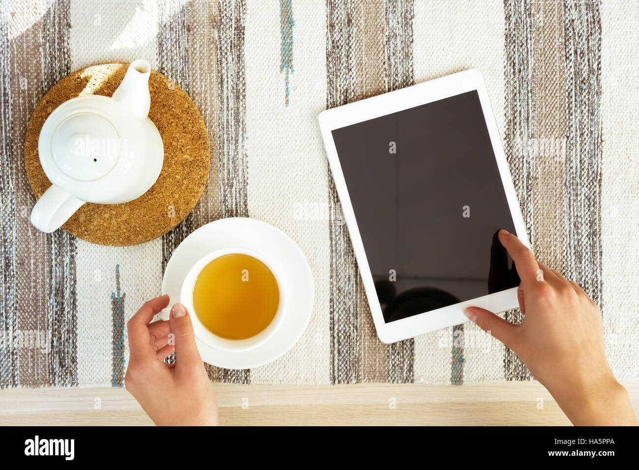 Impostare le mani computer tablet tazza da tè tabella Foto Stock