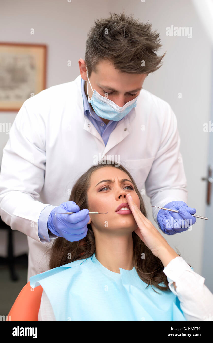 Giovane paziente si lamenta di dentista di dolore di denti Foto Stock