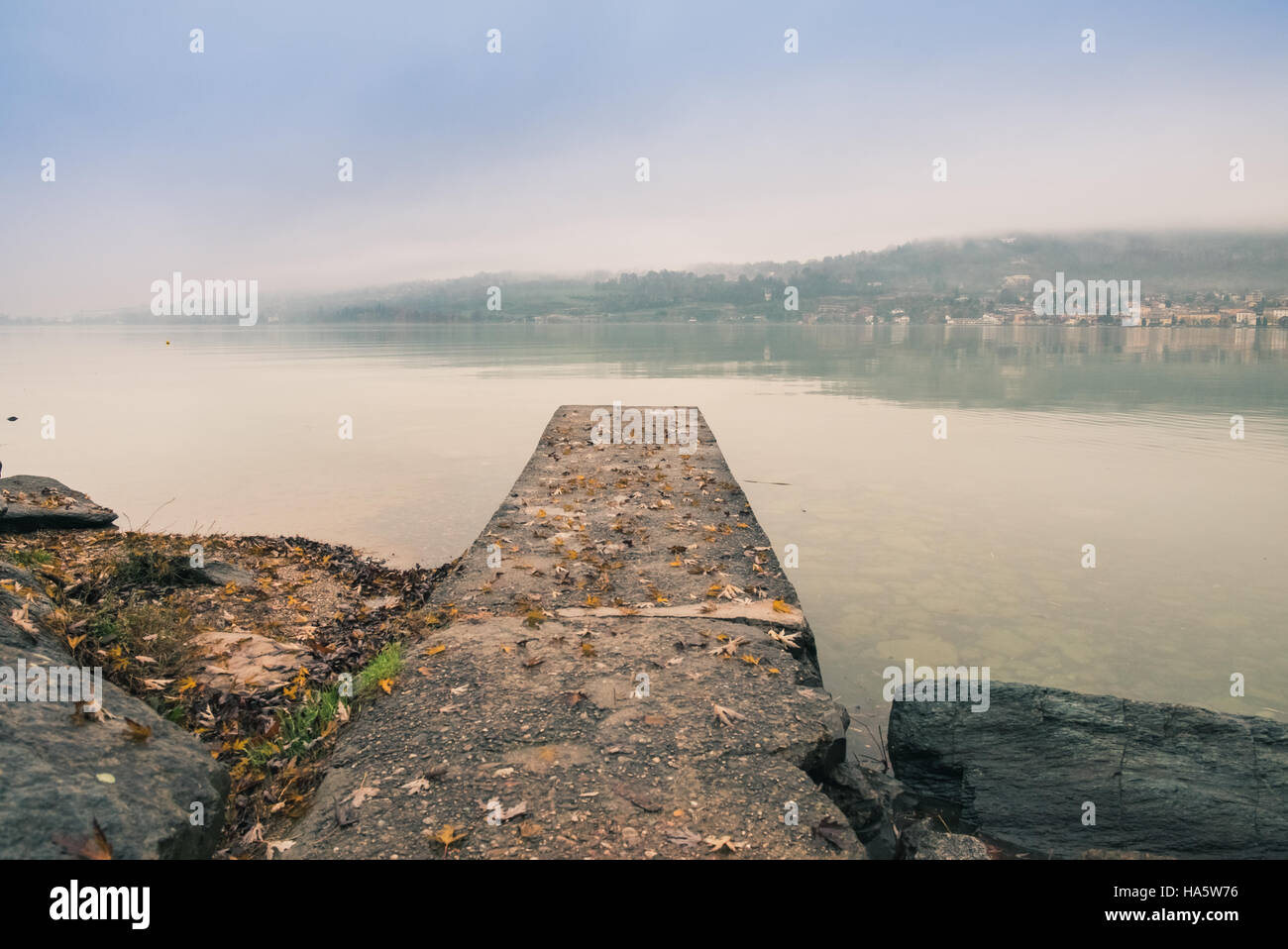 Pier con foglie sul lago in autunno Foto Stock