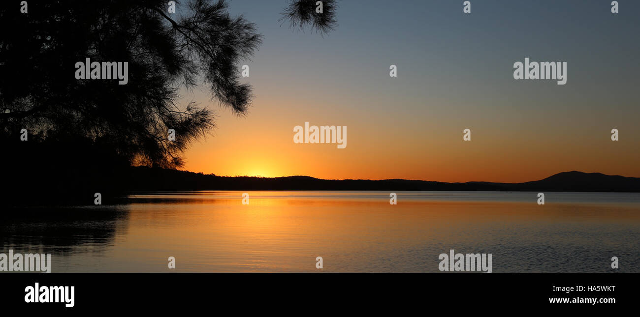 Tramonto a spazzola Mungo campeggio oltre Bombah Broadwater al Myall Lakes National Park in Australia Foto Stock