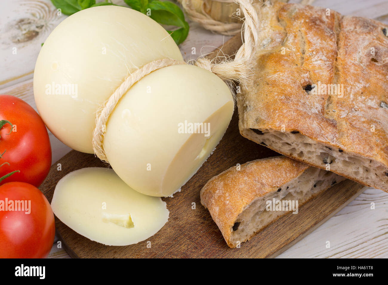 Miglior cibo italiano - fresco formaggio caciocavallo, vino rosso, pane con olive, pomodori Foto Stock