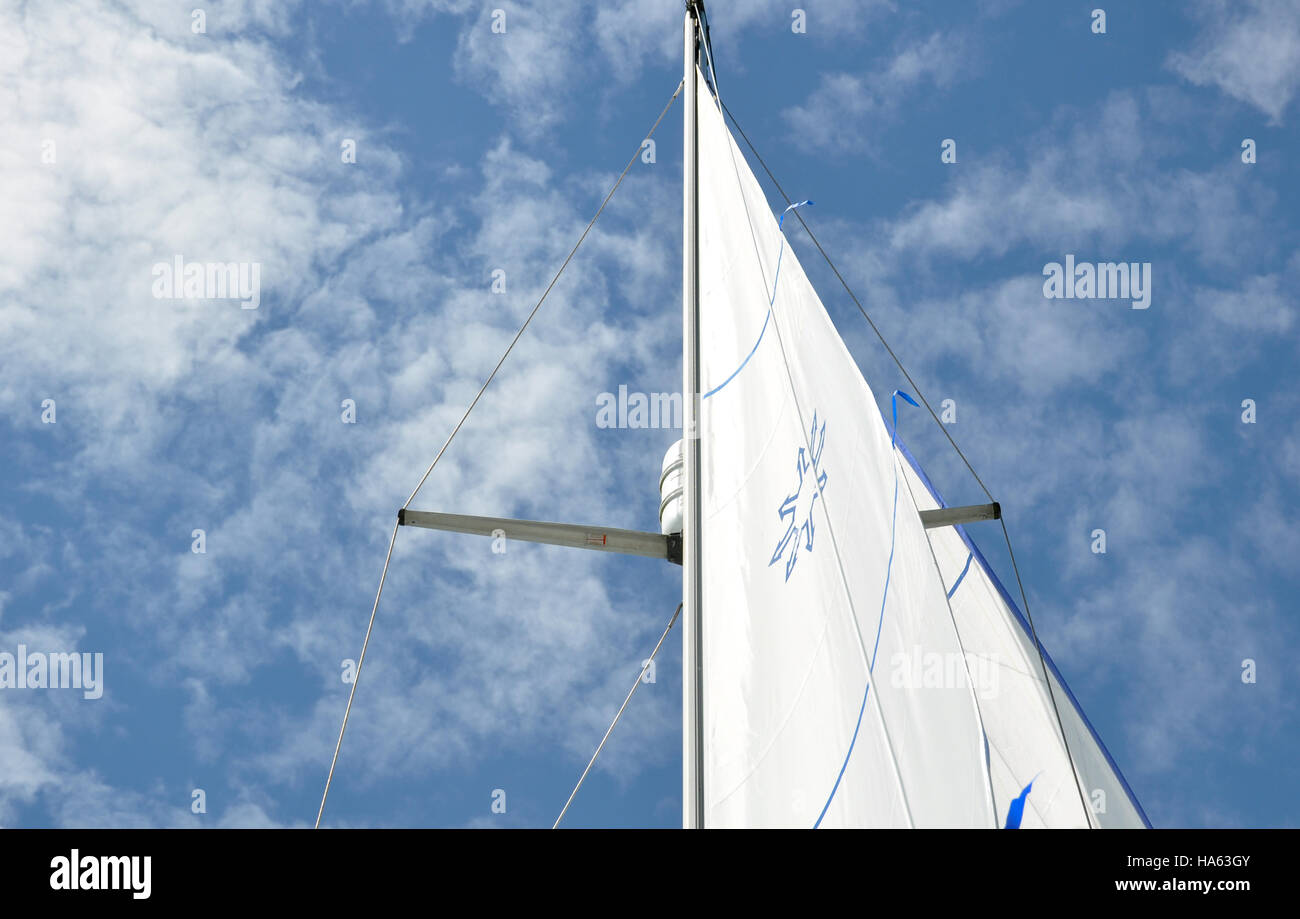 Uno yacht randa contro un cielo blu con nuvole bianche Foto Stock