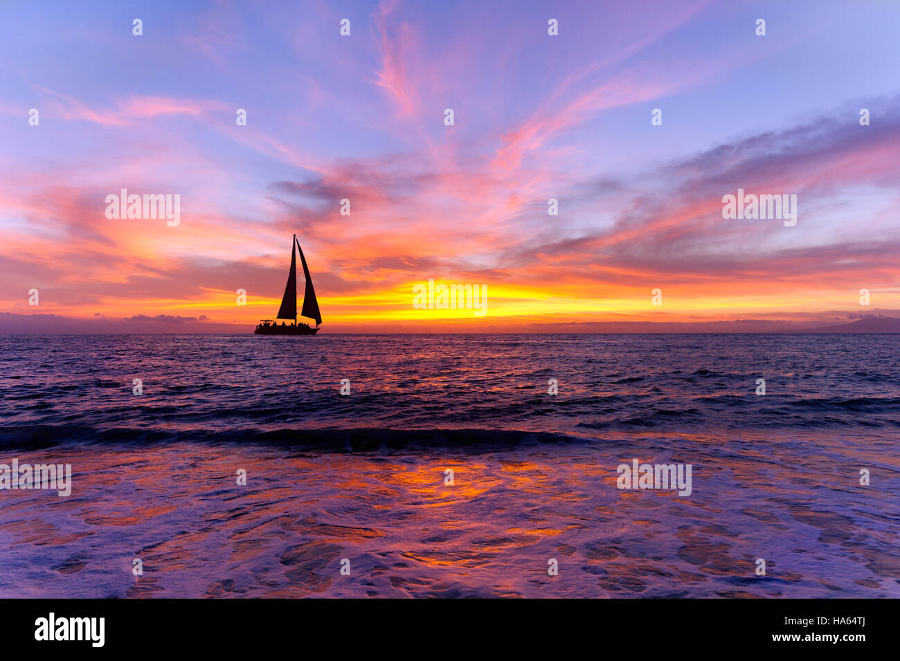 Oceano in barca a vela al tramonto silhouette è in barca a vela vela lungo l'acqua oceanica con un colorato vivid Cielo di tramonto. Foto Stock