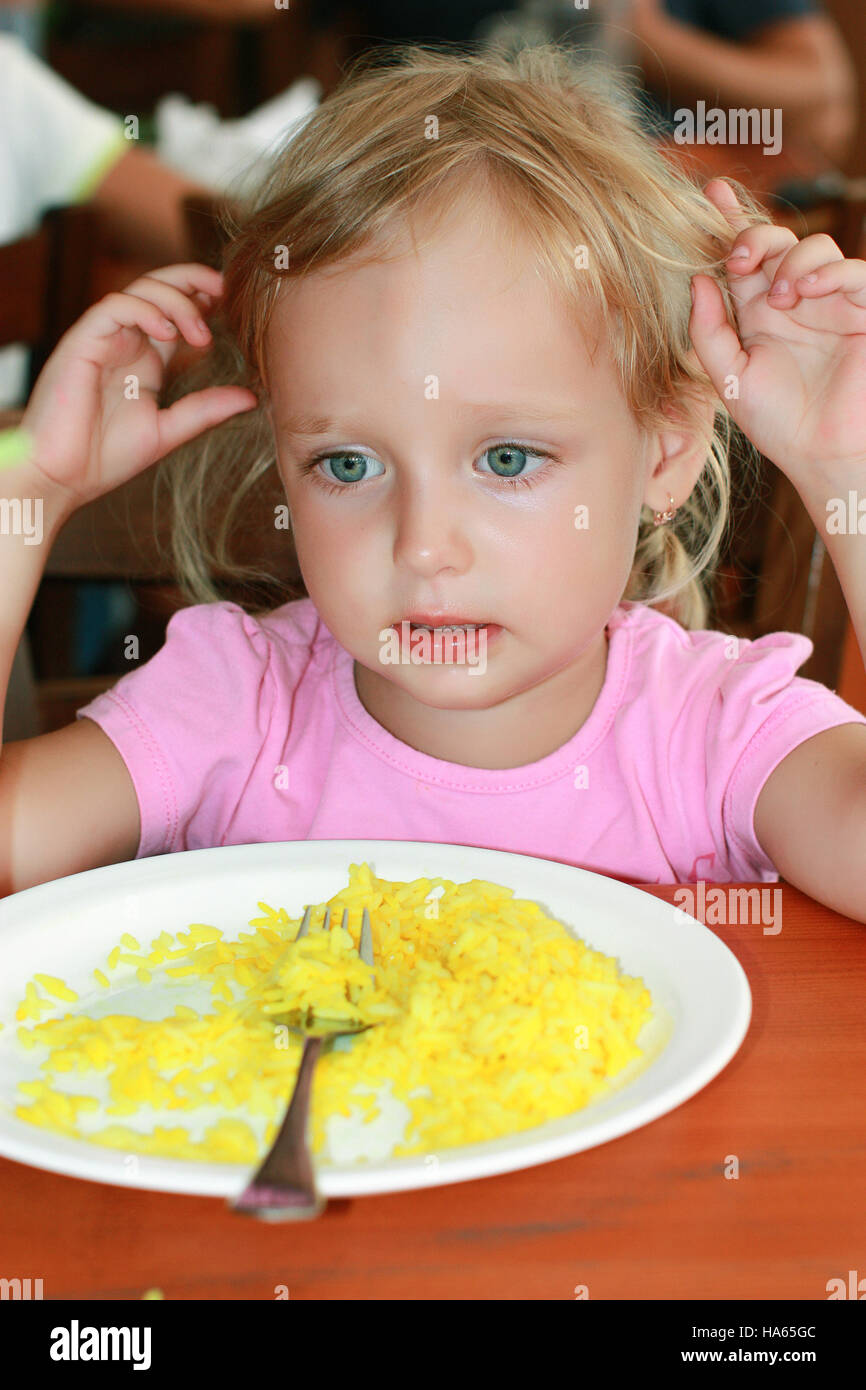 La ragazza mangiò il riso e non vuole più. Foto Stock