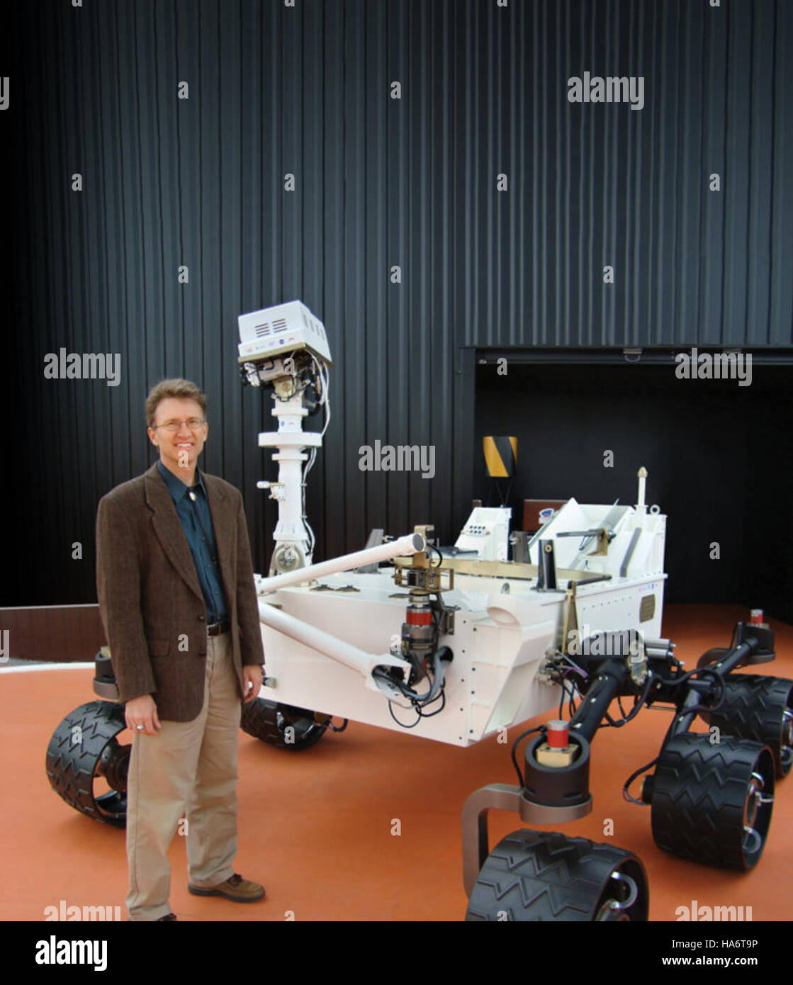 Roger Wiens del Los Alamos National Laboratory è visto con un modello a grandezza naturale del rover Curiosity della NASA. Il modello rappresenta il rover utilizzato per l'esplorazione di Marte, evidenziando l'innovazione nella tecnologia di esplorazione spaziale. Foto Stock