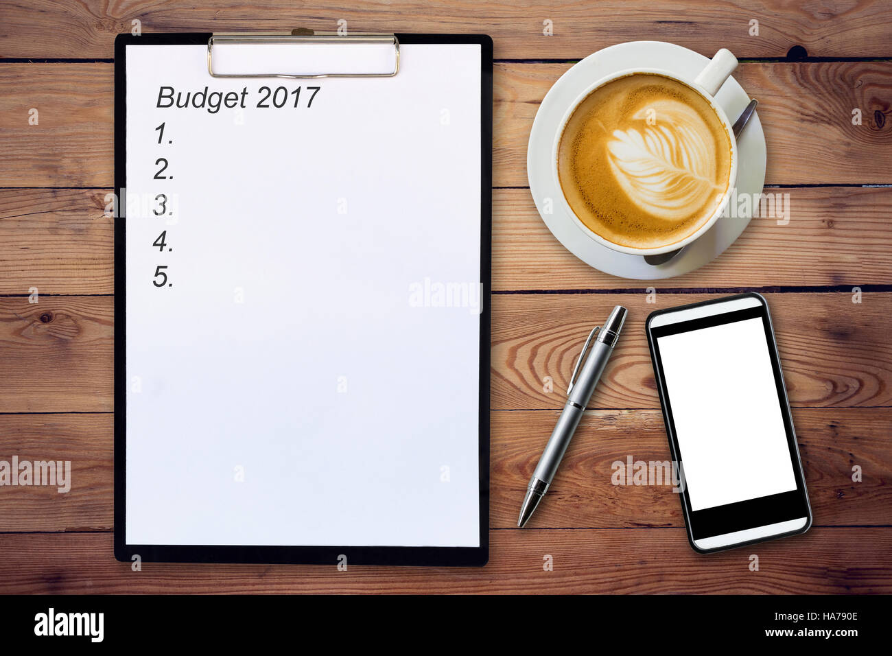 Il concetto di business - vista superiore appunti scrivendo bilancio 2017, penna, tazza di caffè e telefono sul tavolo di legno. Foto Stock