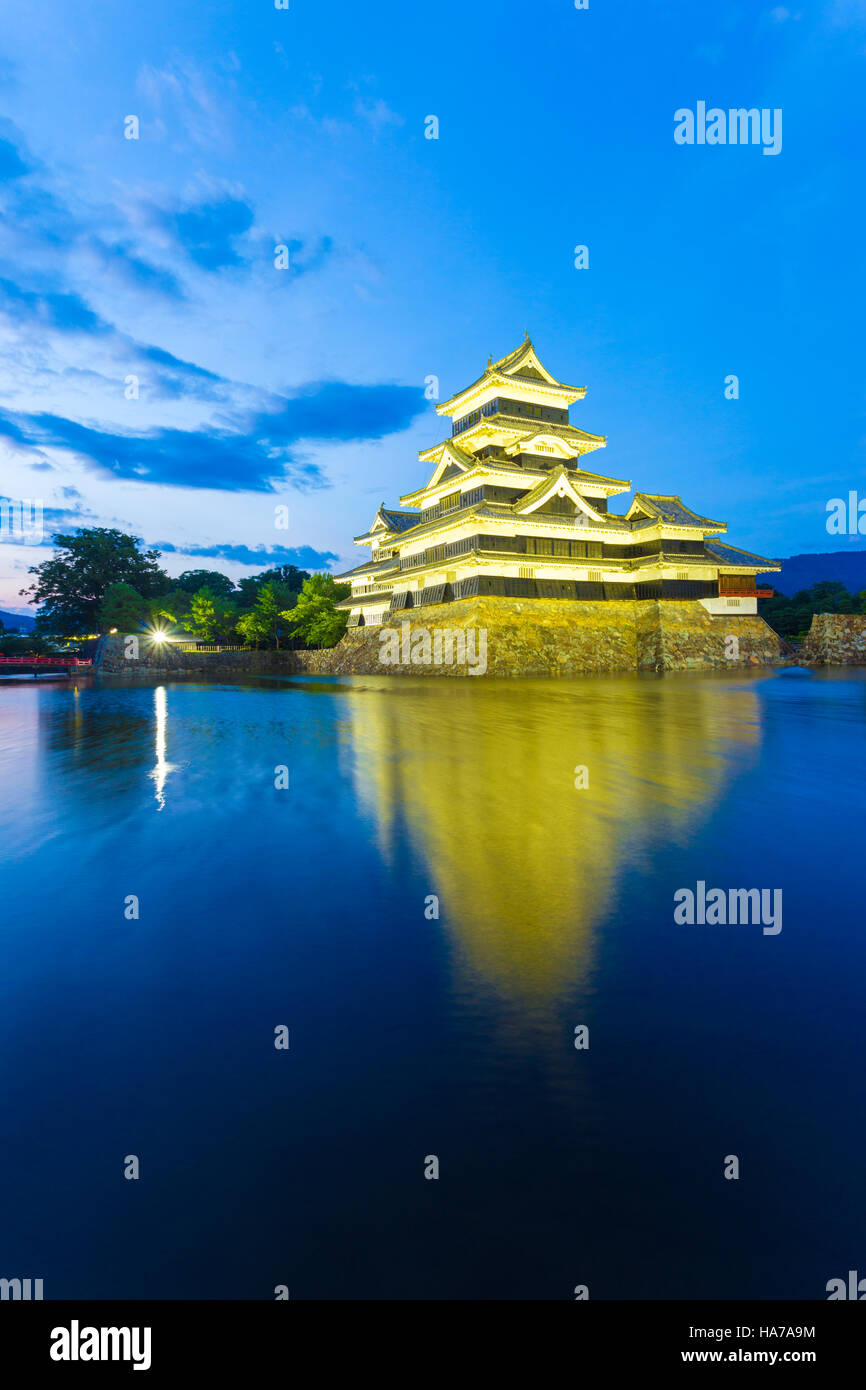 Il Castello Matsumoto splendidamente illuminata di notte blu ora con esposizione lunga riflessione nel fossato acqua nella Prefettura di Nagano, Giappone. Foto Stock
