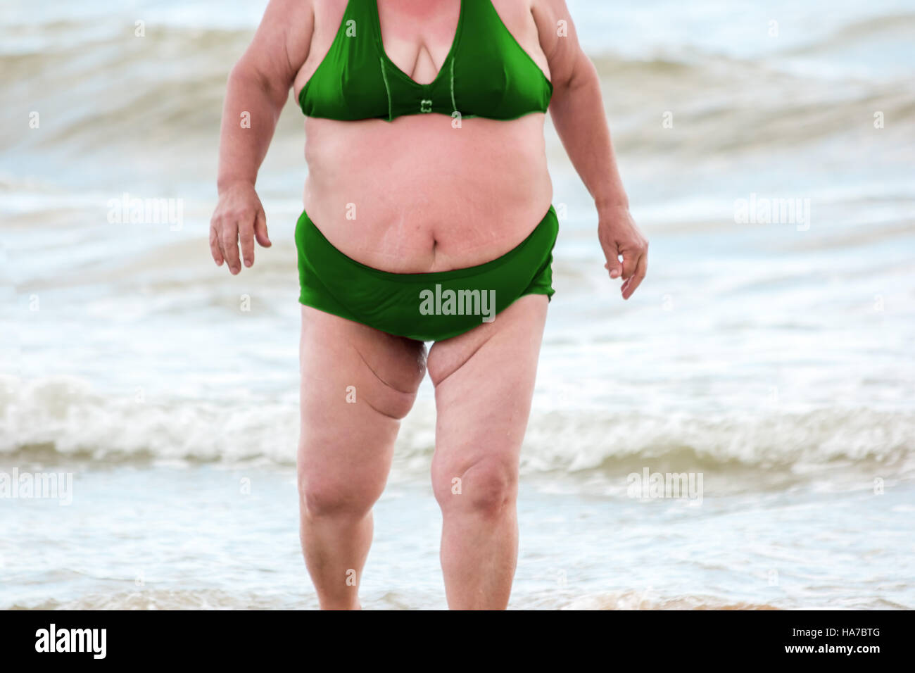 Donna obesa sulla spiaggia. Foto Stock
